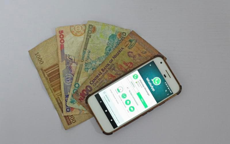 Naira notes next to a smartphone
