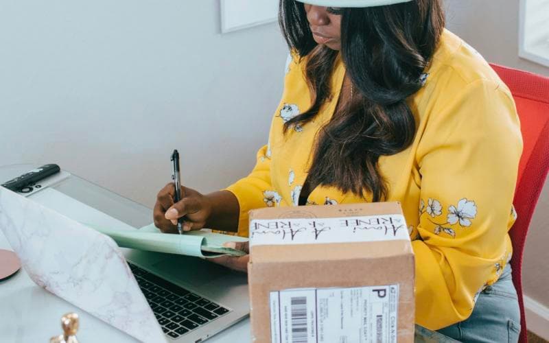 A business owner writing at her desk