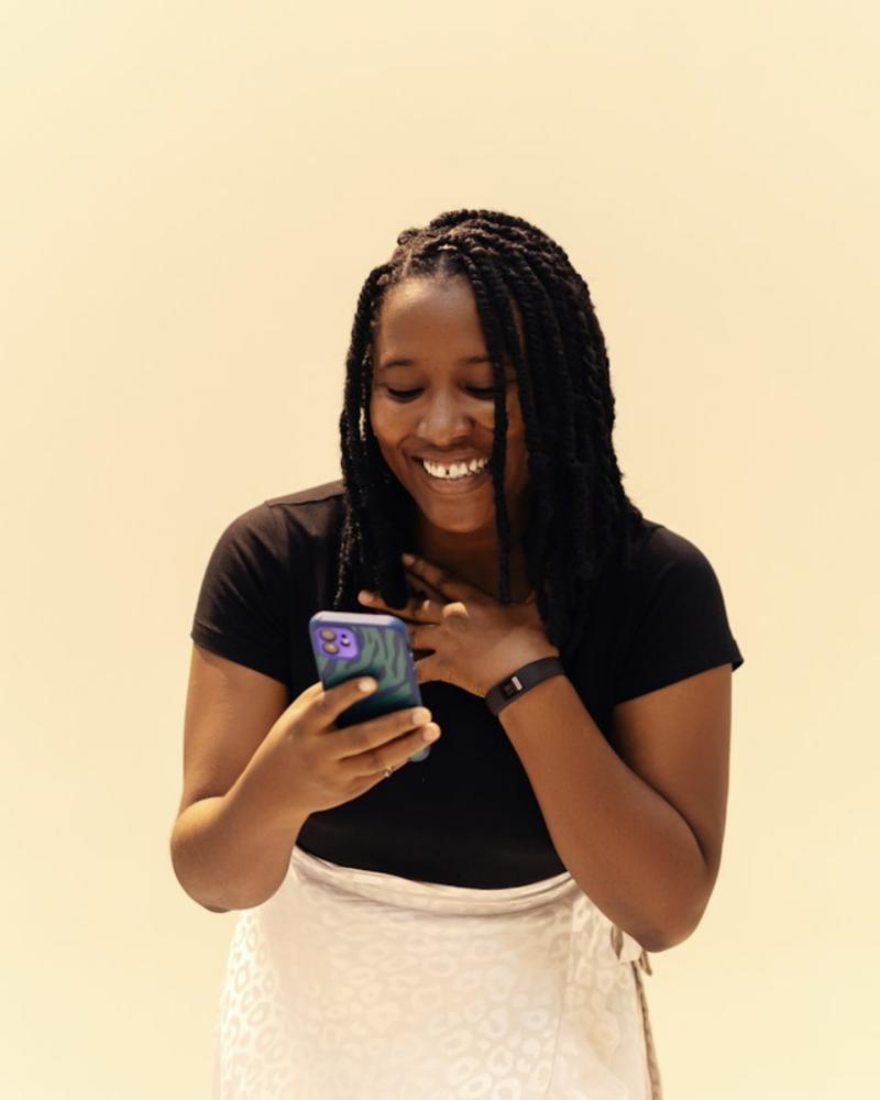 A creator smiling at her phone